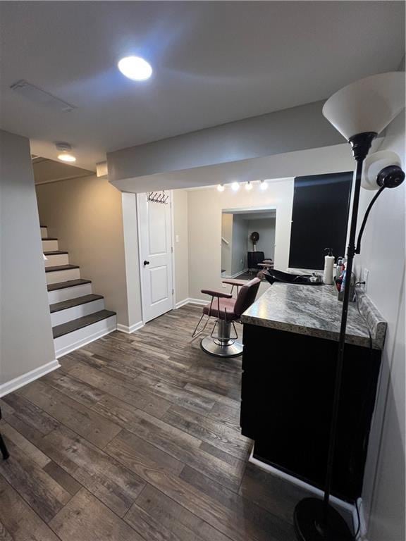 interior space with dark wood-style flooring, stairs, and baseboards