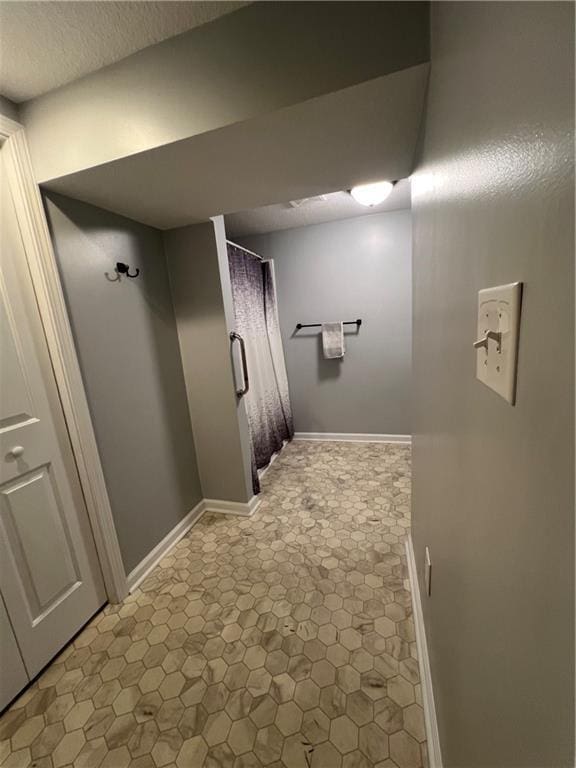 hall featuring baseboards