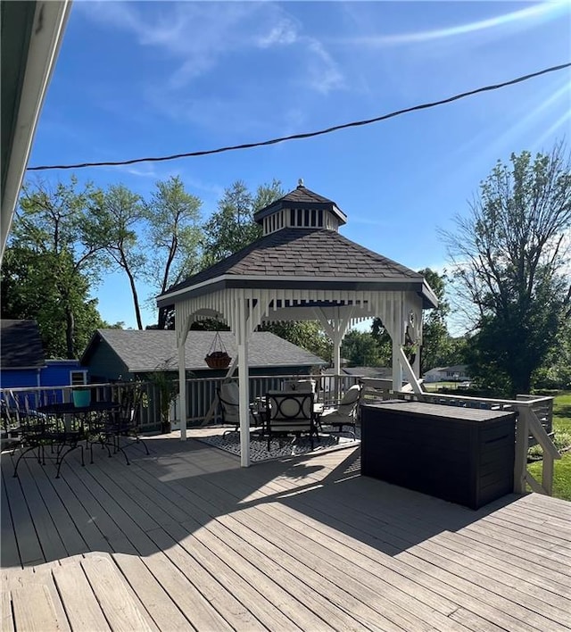 wooden deck featuring a gazebo and outdoor dining space