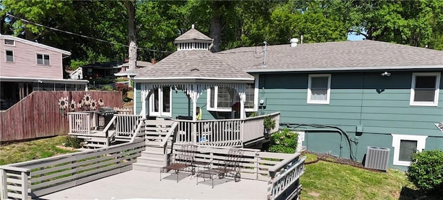 view of front of home with a wooden deck, a shingled roof, and central air condition unit