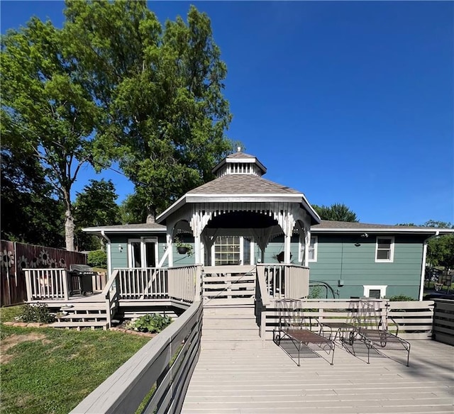 back of house with a gazebo, a wooden deck, and a shingled roof