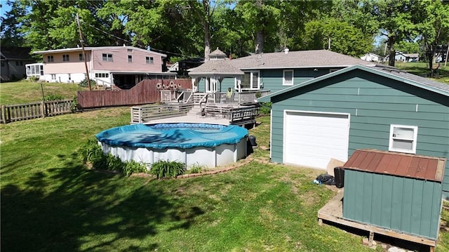 back of house with a gazebo, an outdoor structure, a deck, and a covered pool