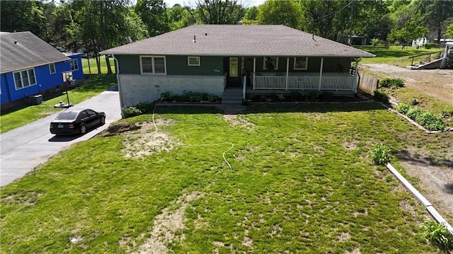 view of front of house featuring covered porch, a front lawn, and driveway