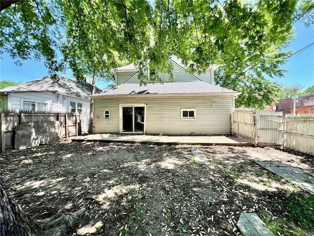 back of house with a fenced backyard, a patio area, and a gate
