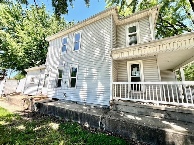 back of property featuring covered porch
