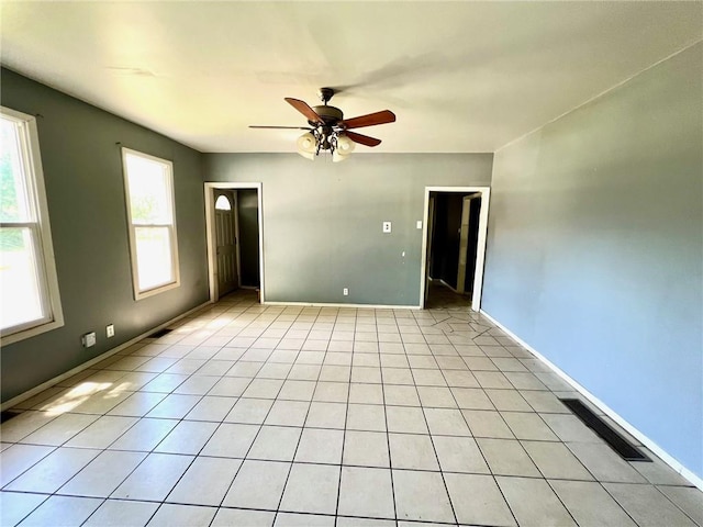 empty room with ceiling fan and baseboards