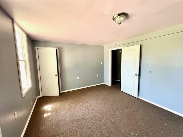 unfurnished bedroom featuring carpet floors and baseboards