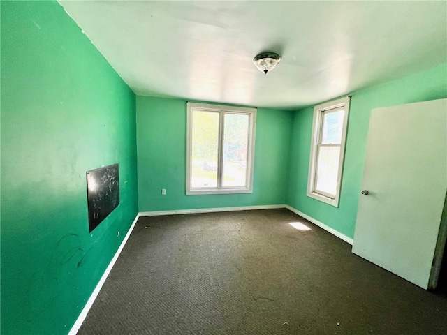 unfurnished room with baseboards and carpet floors