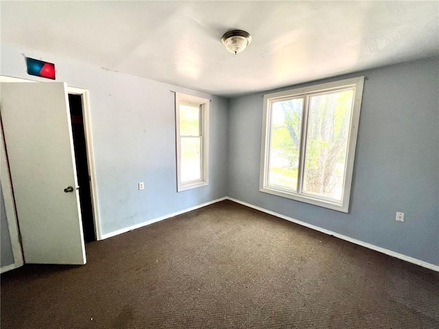 carpeted empty room featuring baseboards