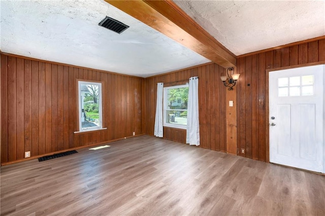 2409 Oakley Ave, Kansas City, MO 64127 - entrance foyer featuring wood finished floors, healthy amount of natural light, beam ceiling, and wood walls