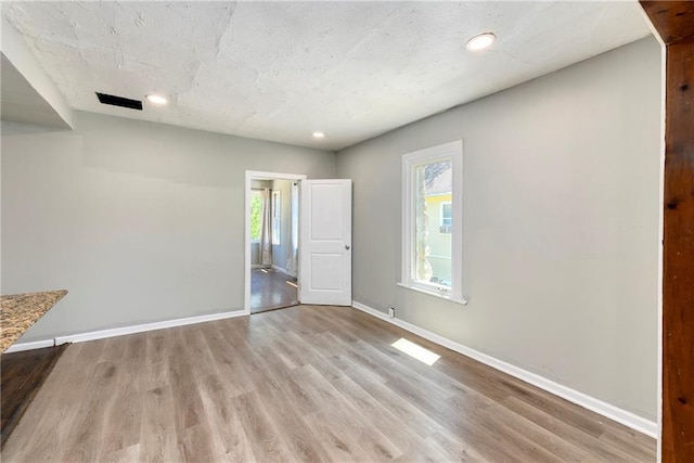 2409 Oakley Ave, Kansas City, MO 64127 - unfurnished bedroom with wood finished floors, baseboards, and recessed lighting