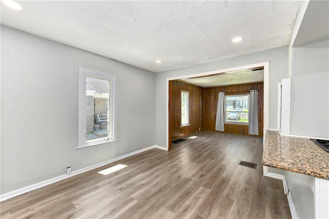 2409 Oakley Ave, Kansas City, MO 64127 - unfurnished living room with wood finished floors, baseboards, and recessed lighting