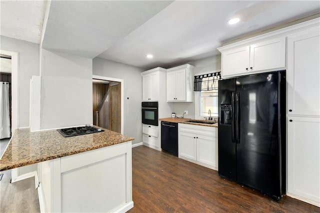 2409 Oakley Ave, Kansas City, MO 64127 - kitchen with black appliances, a sink, white cabinets, dark wood finished floors, and light stone countertops