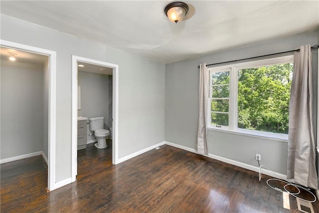 2409 Oakley Ave, Kansas City, MO 64127 - unfurnished bedroom with baseboards and wood finished floors