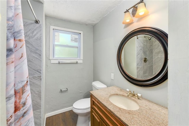 2409 Oakley Ave, Kansas City, MO 64127 - bathroom featuring wood finished floors, baseboards, toilet, curtained shower, and vanity
