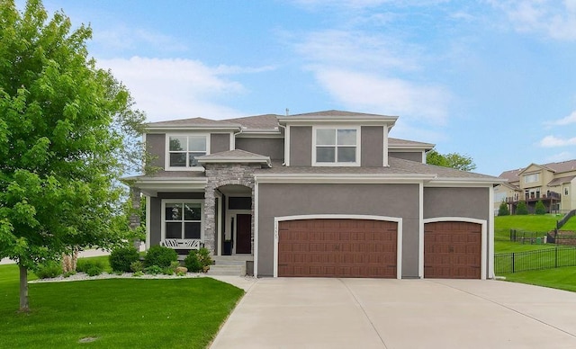 prairie-style house with stucco siding, concrete driveway, and a garage