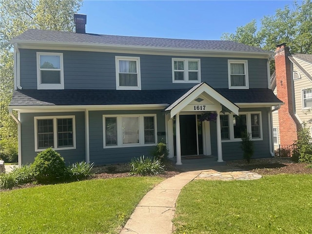 1617 W 50th St, Kansas City, MO 64112 - view of front of house with a front yard, a chimney, and roof with shingles