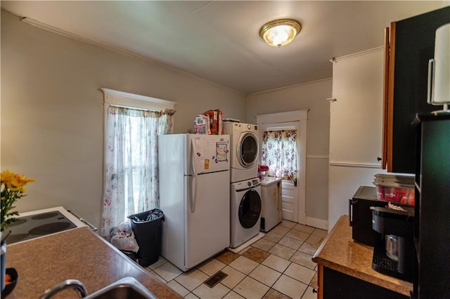 911 N 6th St, Atchison, KS 66002 - kitchen with white appliances, estacked washer and dryer, light tile patterned floors, and ornamental molding