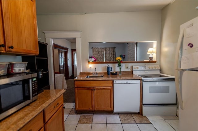 911 N 6th St, Atchison, KS 66002 - kitchen with white appliances, a sink, light tile patterned floors, and brown cabinets