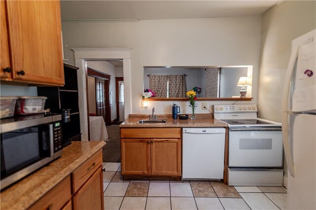 911 N 6th St, Atchison, KS 66002 - kitchen with white appliances, a sink, light tile patterned floors, and brown cabinetry