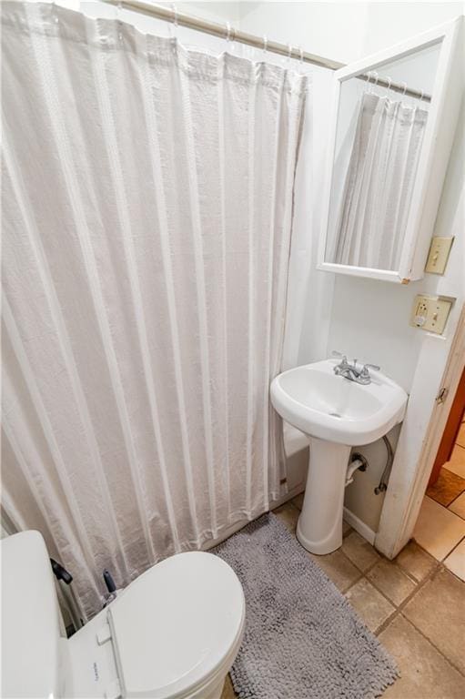 911 N 6th St, Atchison, KS 66002 - bathroom featuring toilet, tile patterned floors, and a sink