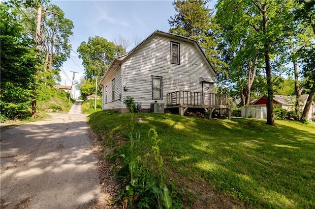 911 N 6th St, Atchison, KS 66002 - rear view of house with a wooden deck, a lawn, and central AC