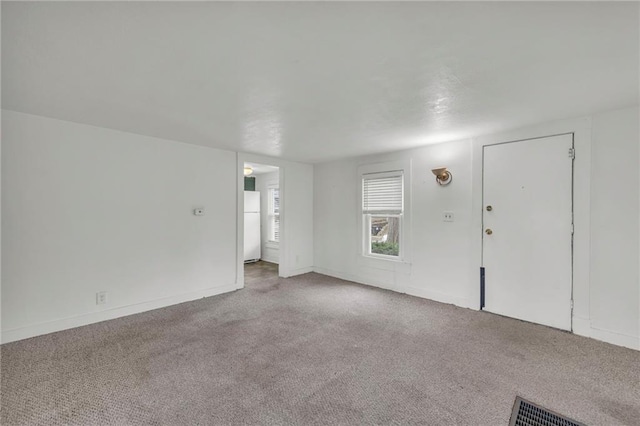 unfurnished living room with carpet floors and baseboards