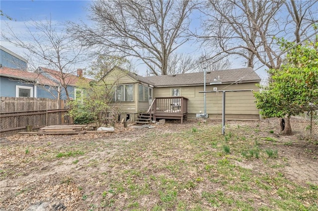 rear view of house featuring a deck and fence