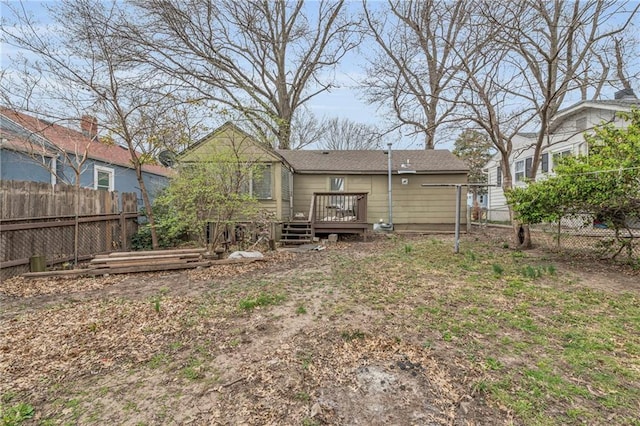 rear view of property with a wooden deck and fence