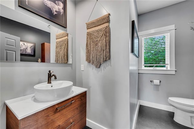 11261 238th St, Lawrence, KS 66044 - bathroom featuring baseboards, toilet, vanity, and concrete flooring