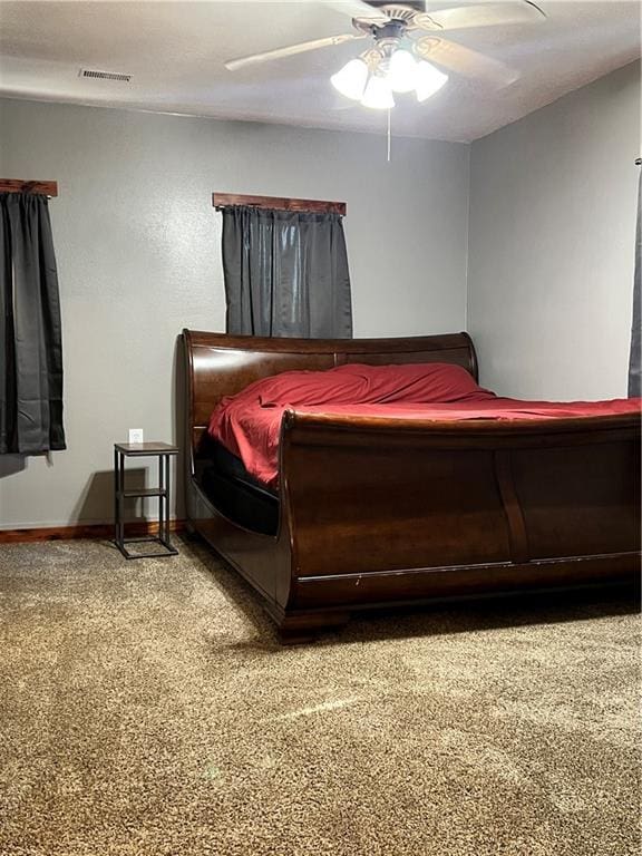 702 N Cedar St, Nevada, MO 64772 - carpeted bedroom with baseboards and a ceiling fan