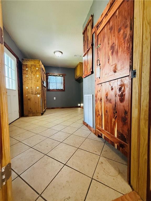 702 N Cedar St, Nevada, MO 64772 - kitchen featuring light tile patterned flooring, plenty of natural light, and brown cabinets