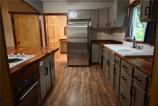 702 N Cedar St, Nevada, MO 64772 - kitchen featuring butcher block counters, freestanding refrigerator, gray cabinets, white electric cooktop, and wood finished floors