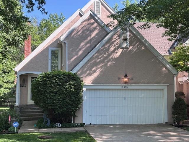 9803 W 121st St, Overland Park, KS 66213 - view of front of property featuring a garage, driveway, stucco siding, and a chimney