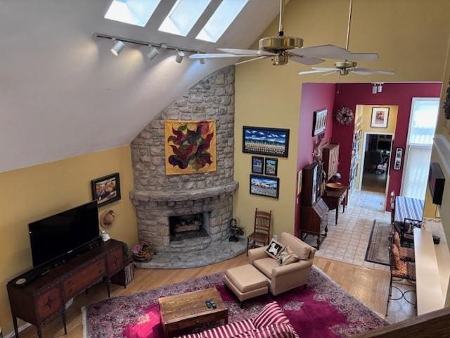 9803 W 121st St, Overland Park, KS 66213 - living room with a skylight, wood finished floors, lofted ceiling, a stone fireplace, and ceiling fan