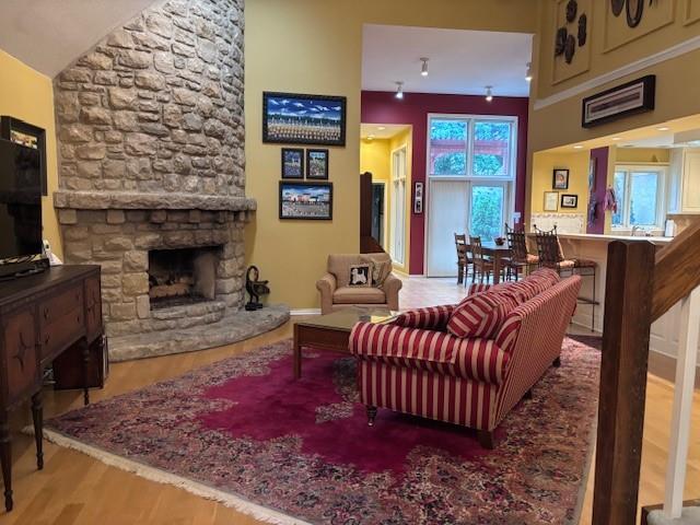 9803 W 121st St, Overland Park, KS 66213 - living room with wood finished floors, a fireplace, and vaulted ceiling