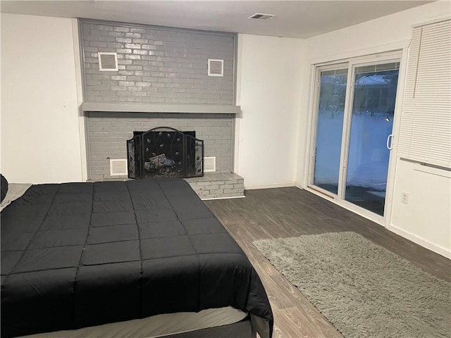 2911 S 26th St, Kansas City, KS 66106 - bedroom featuring wood finished floors, access to outside, a fireplace, and baseboards
