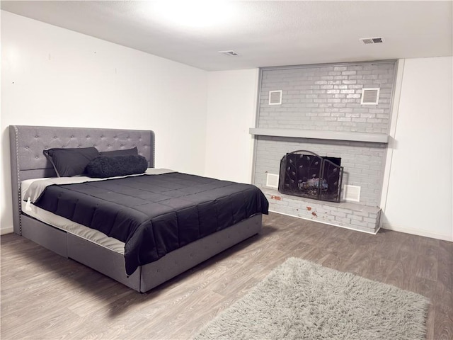 2911 S 26th St, Kansas City, KS 66106 - bedroom with wood finished floors, a fireplace, and baseboards