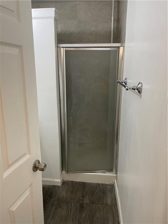 2911 S 26th St, Kansas City, KS 66106 - full bath with baseboards, a shower stall, and wood finished floors