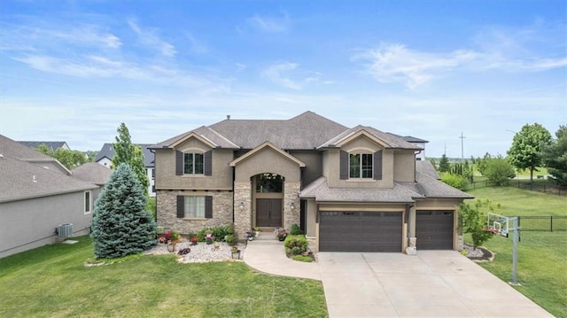 15825 Howe St, Overland Park, KS 66224 - view of front of home featuring stucco siding, central AC, driveway, an attached garage, and stone siding