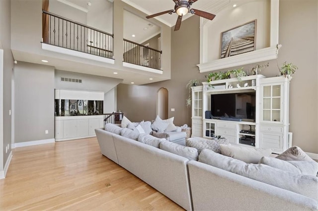 15825 Howe St, Overland Park, KS 66224 - living room with a ceiling fan, wood finished floors, baseboards, ornamental molding, and a high ceiling