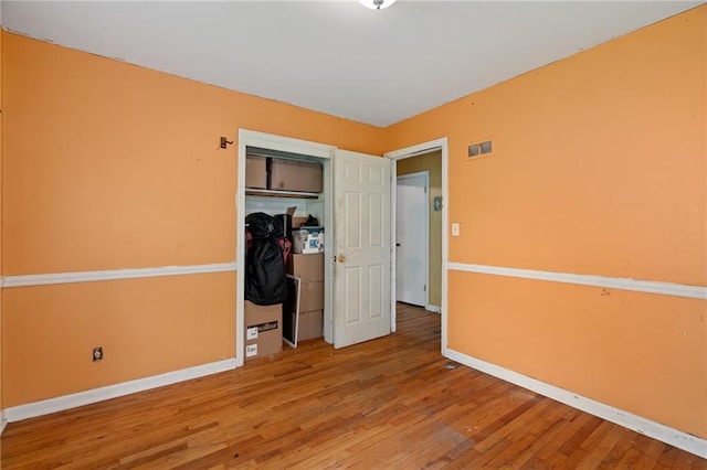 5347 Buena Vista St, Roeland Park, KS 66205 - unfurnished bedroom with wood finished floors, baseboards, and a closet