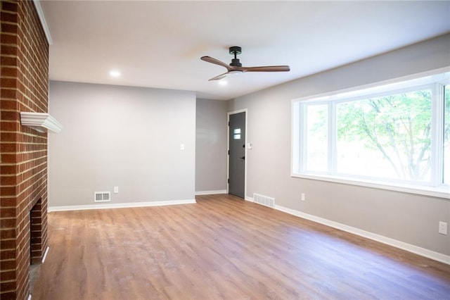 205 55th Ter, Kansas City, MO 64118 - unfurnished living room featuring a brick fireplace, ceiling fan, wood finished floors, baseboards, and recessed lighting
