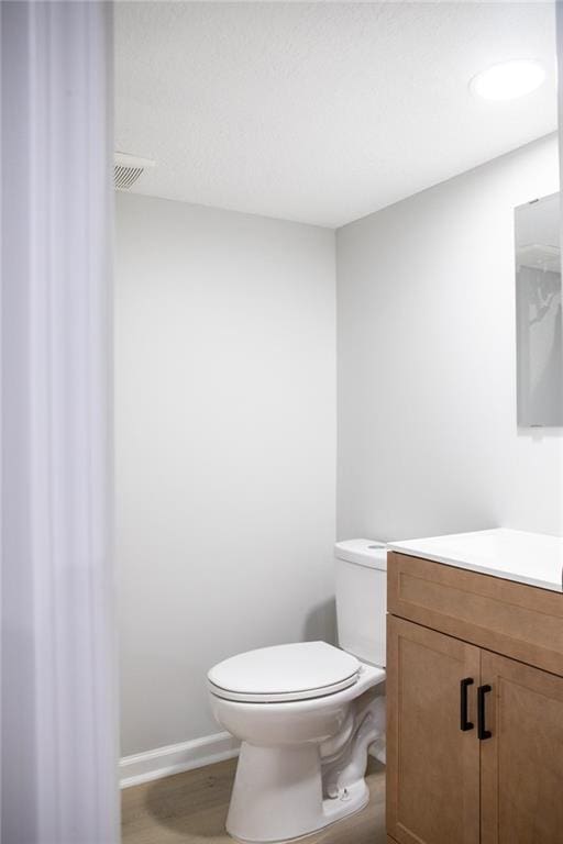 205 55th Ter, Kansas City, MO 64118 - half bath with vanity, toilet, and wood finished floors