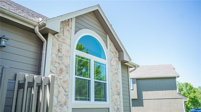exterior view of stone siding, gutters, and a downspout