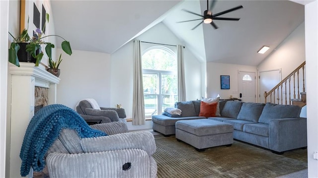 living area with a ceiling fan, lofted ceiling, stairway, and a fireplace