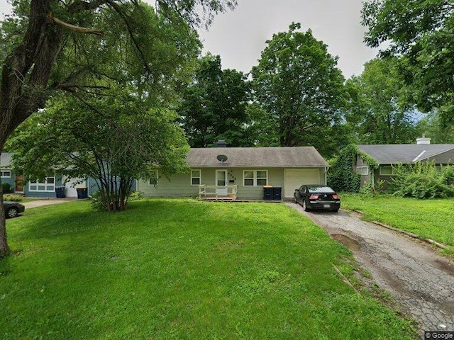 ranch-style house with asphalt driveway, a garage, a front yard, and covered porch