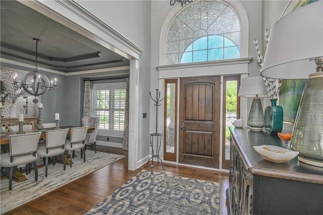 4502 Verona Ct, Riverside, MO 64150 - entryway with a chandelier, wood finished floors, ornamental molding, a tray ceiling, and baseboards