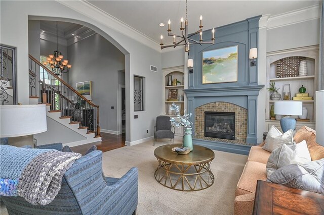 4502 Verona Ct, Riverside, MO 64150 - carpeted living room featuring a chandelier, crown molding, built in shelves, baseboards, and a fireplace