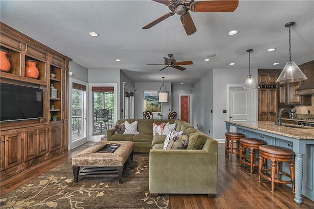 4502 Verona Ct, Riverside, MO 64150 - living area featuring dark wood-style floors, a ceiling fan, recessed lighting, baseboards, and a textured ceiling
